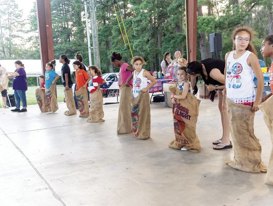 The sack race competitors line up for a heated race during the Shepherd Fourth of July