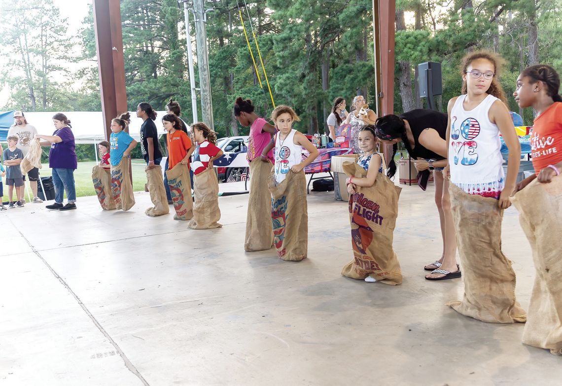 The sack race competitors line up for a heated race during the Shepherd Fourth of July