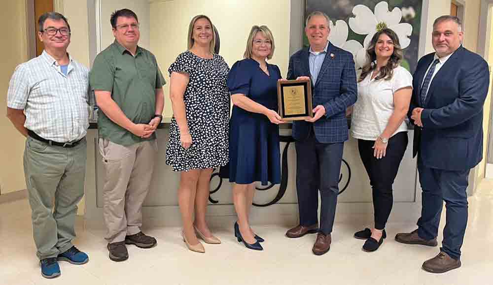 Tyler County Hospital CEO Sondra Williams (middle) receives a plaque from the American Hospital Association’s David Pearson to commemorate TCH for 50 years as an AHA member hospital. Pictured left-to-right: Scott McCluskey; James Stevens; Janay Yancey; Williams; Pearson; Connie Sturrock and Judge Milton Powers. COURTESY PHOTO