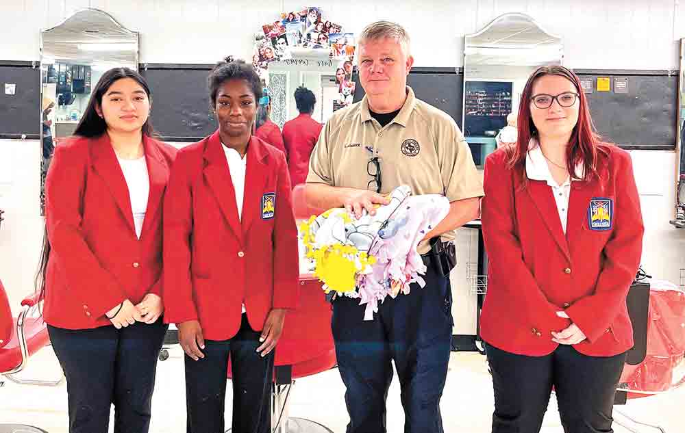 Groveton ISD cosmetology students present Constable Lawrence Adamick with blankets created by the class. Courtesy photo