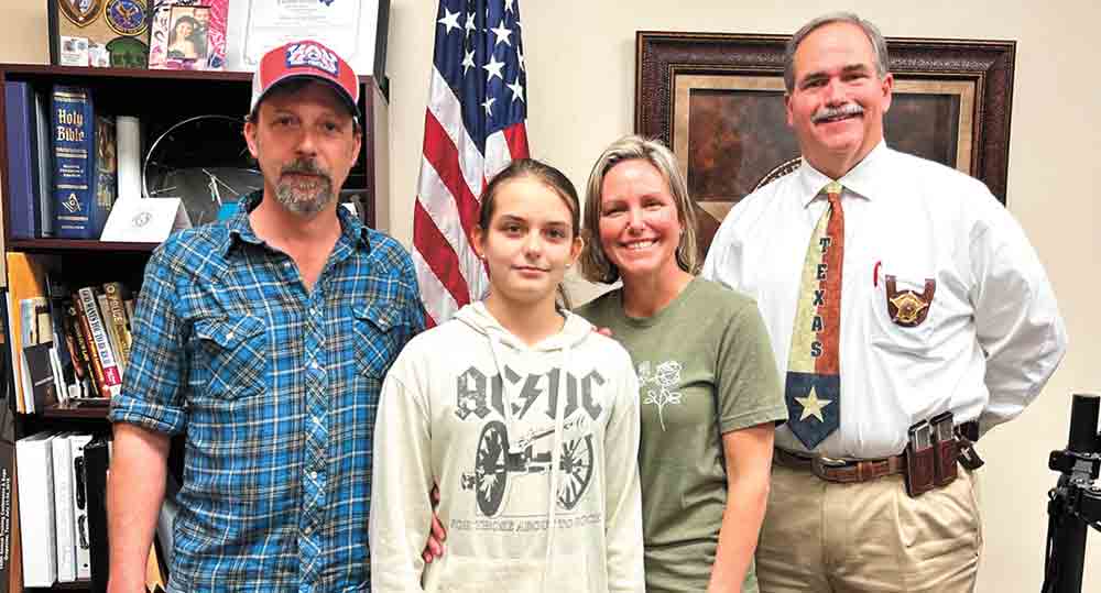 The Savell family, including dad Jeremy Savell, Rachel and mom Mara Savell, along with Sheriff Greg Capers.