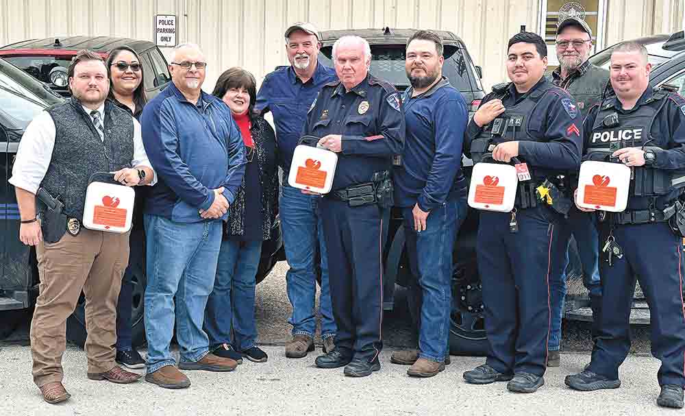 Corrigan Police officers show off the new defibrillators they recently put in all the department’s patrol cars.  Made possible by a financial contribution by Georgia-Pacific, the medical devices will assist officers when responding to heart-related medical emergencies.  Pictured (l-r) are Jason Porter, Corrigan Police Detective; Aliyah Brown, Corrigan Administrative Assistant; Darrian Hudman, Corrigan City Manager; Johnna Lowe-Gibson, Corrigan Mayor; George Standley, Georgia-Pacific Camden Plywood Plant Manager; Darrell Gibson, Corrigan Police Chief; Lester Knight, Georgia-Pacific Corrigan Plywood Plant Manager; Fitzpatrick Foster, Police Corporal; Myrton Thompson, Georgia-Pacific Camden Lumber Plant Manager; Jonathan Reynolds, Corrigan Police Officer. Courtesy photo