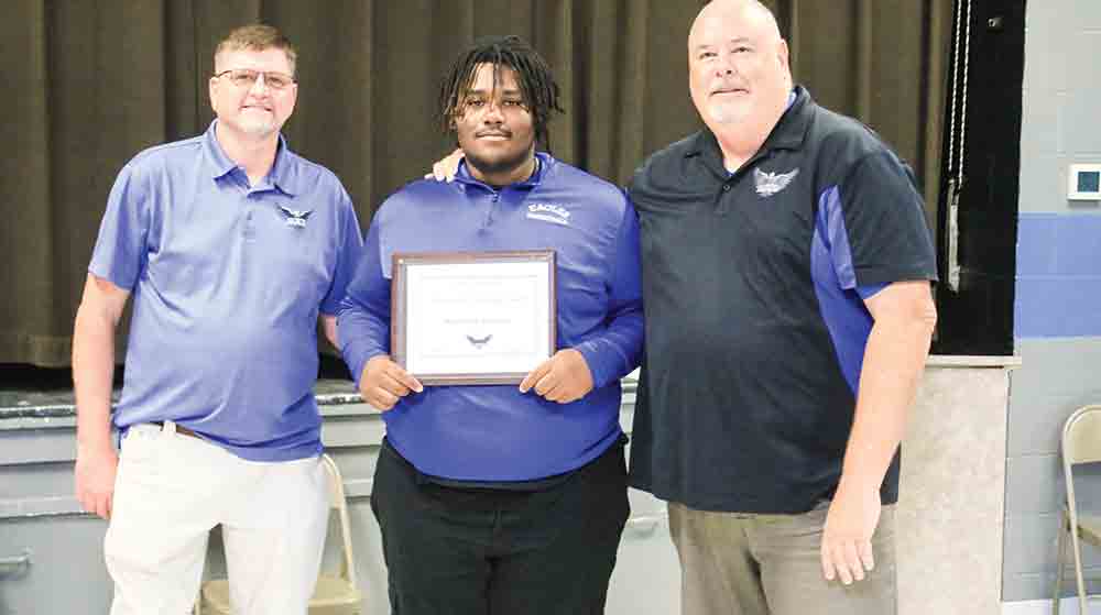 Apple Springs Principal Kevin Plotts and Superintendent Dr. Cody Moree congratulate Kameron Spencer, who was awarded the Heart of and Eagle Award for his exemplary performance in all sports. PHOTOS BY TONY FARKAS