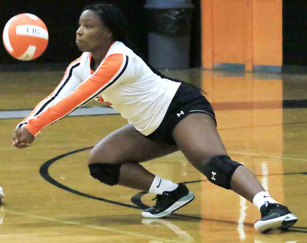 Trinity libero Quianna O’Bryant digs up a serve.