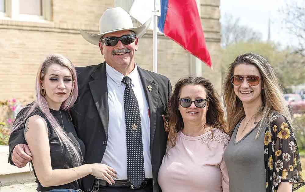 The family of Neil Adams stands with Sheriff Greg Capers.  Photo by Charles Ballard