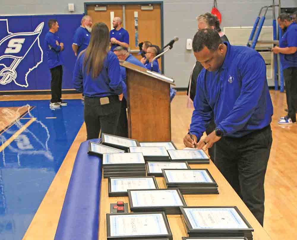 Shepherd ISD Coach Eldridge McAdams checks the roster of awards at the annual sports banquet. Photo by Tony Farkas