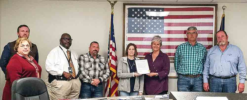 The Polk County Commissioners Court issued a proclamation for Public Safety Telecommunications Week during its regular meeting Tuesday. (l-r) Precinct 1 Commissioner Guylene Robertson, Chief Deputy Rickie Childers, Sheriff Byron Lyons, Precinct 2 Commissioner Mark Dubose, Telecommunications Operator Debbie Oxford, County Judge Sydney Murphy, Precinct 4 Commissioner Jerry Cassity and Precinct 3 Commissioner Milt Purvis. Photo by Emily Banks Wooten