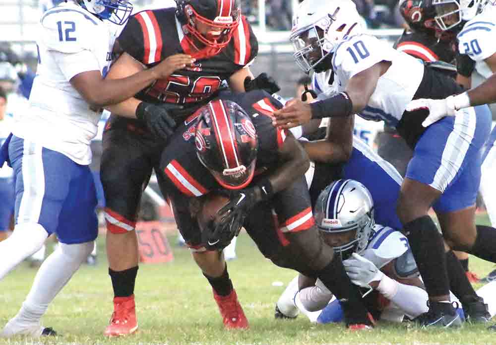 Javious Parker punches through the defensive line. Photo by Tony Farkas