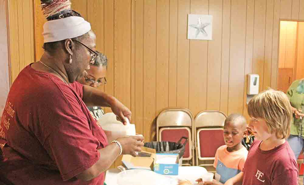 Volunteer Stacy Barkins serves up tasty, nutritious treats to the participants of the after-school program at Pleasant Hill Missionary Baptist Church. CHRIS EDWARDS | TCB