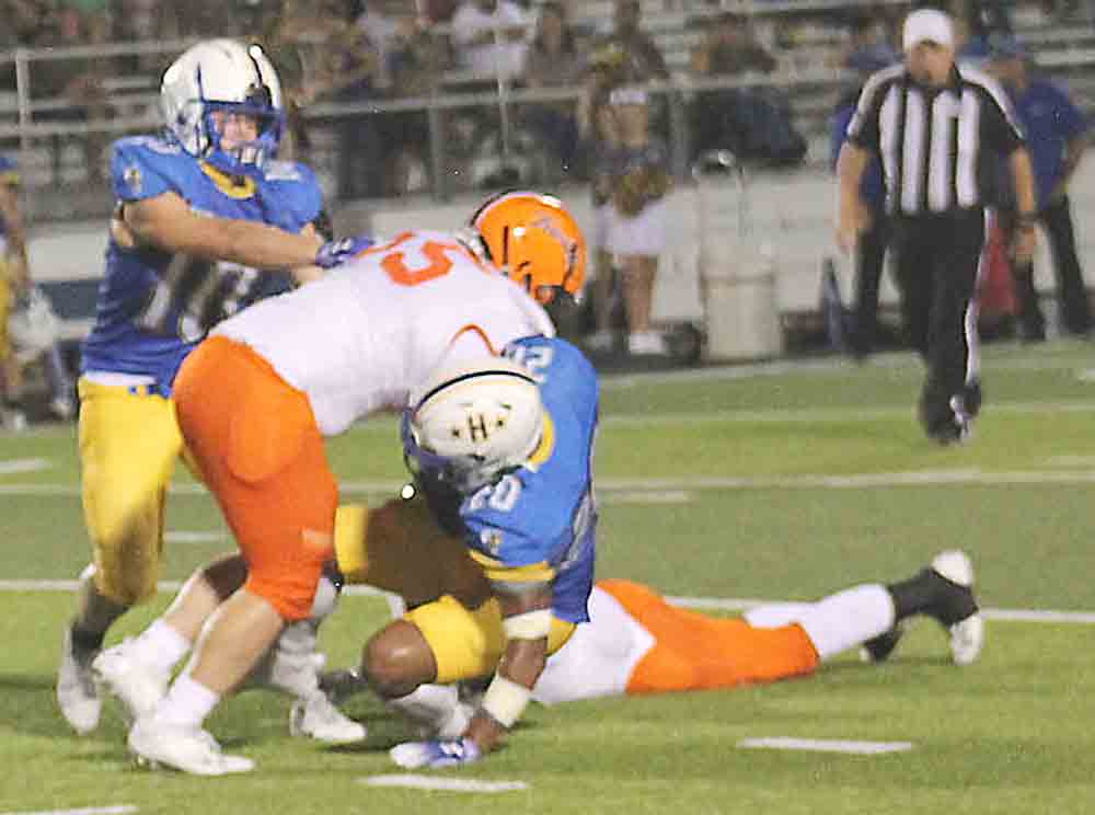 Above: Trinity players swarm a Hardin runner. At right: A Trinity Tiger takes the kickoff. Photo by Scott Womack