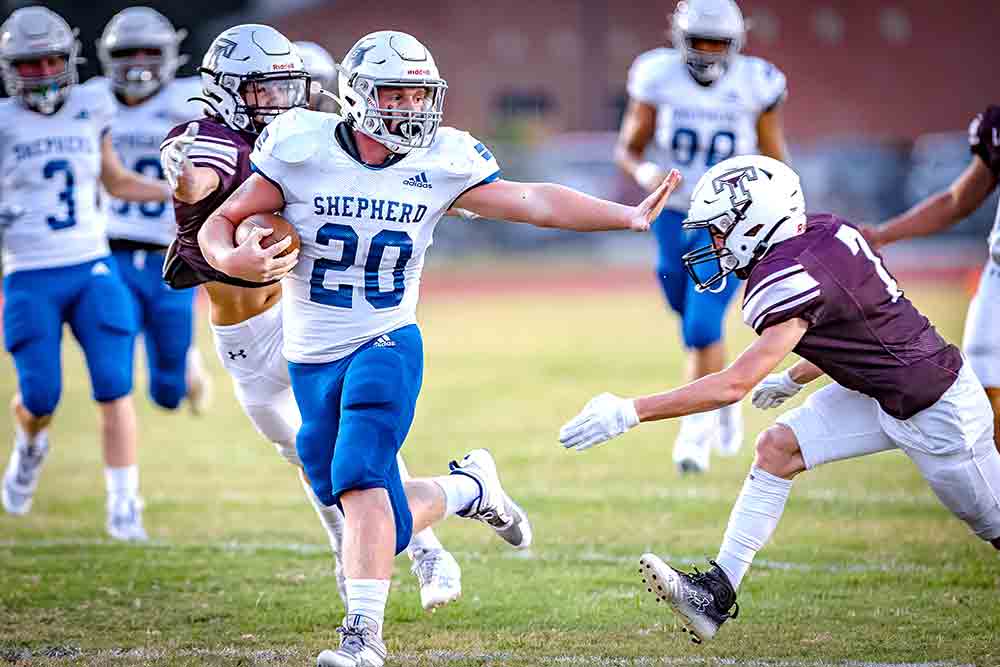 Preston Stephens (No. 20) stiffarms his way to a long gain during the first quarter. Photos by Charles Ballard