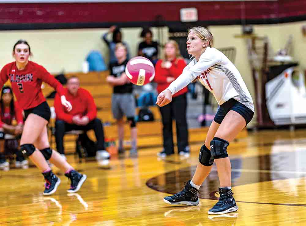 Small but “Mity” Libero Tess Phillips sets the ball for another score for the Lady Trojans.