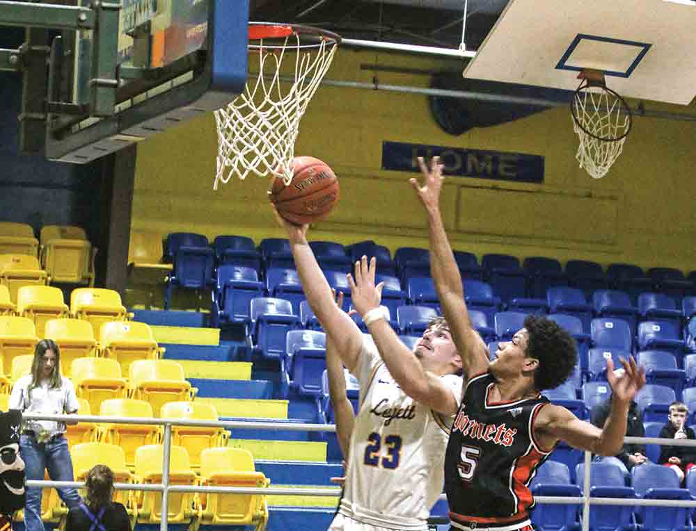 Gavin Nichols is challenged by two Hornets at the rim.