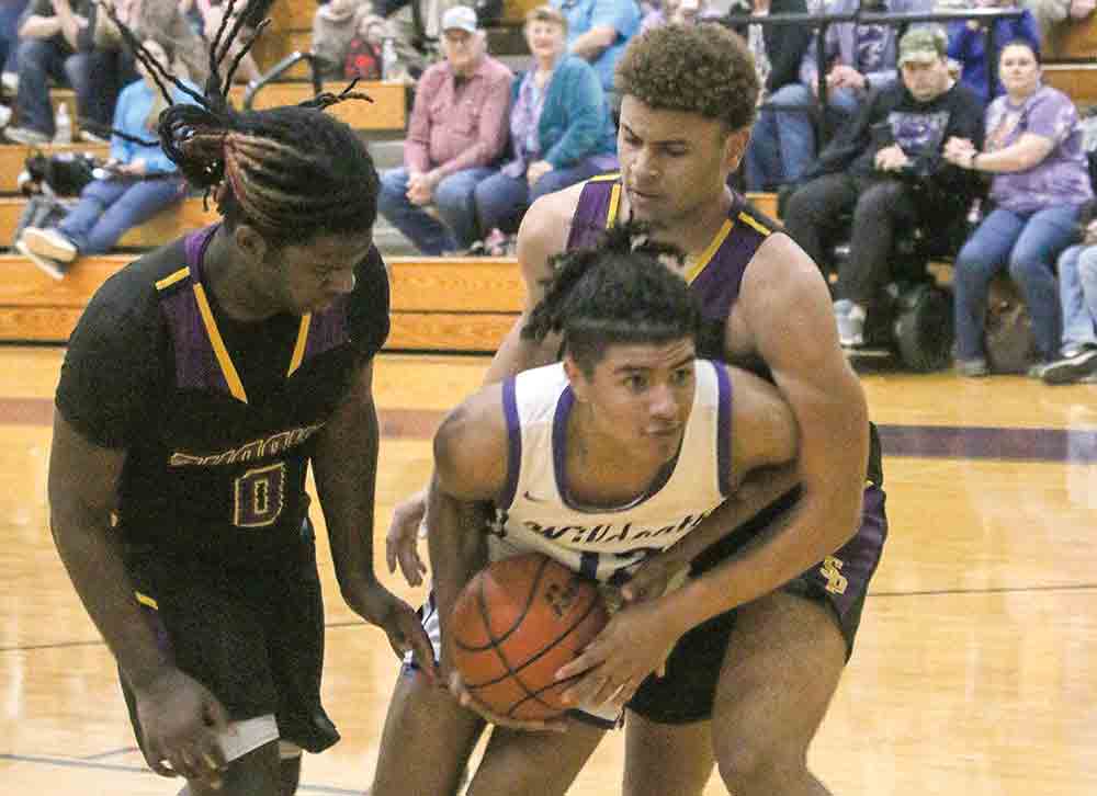 Javen Criswell fights through the defense under the bucket.