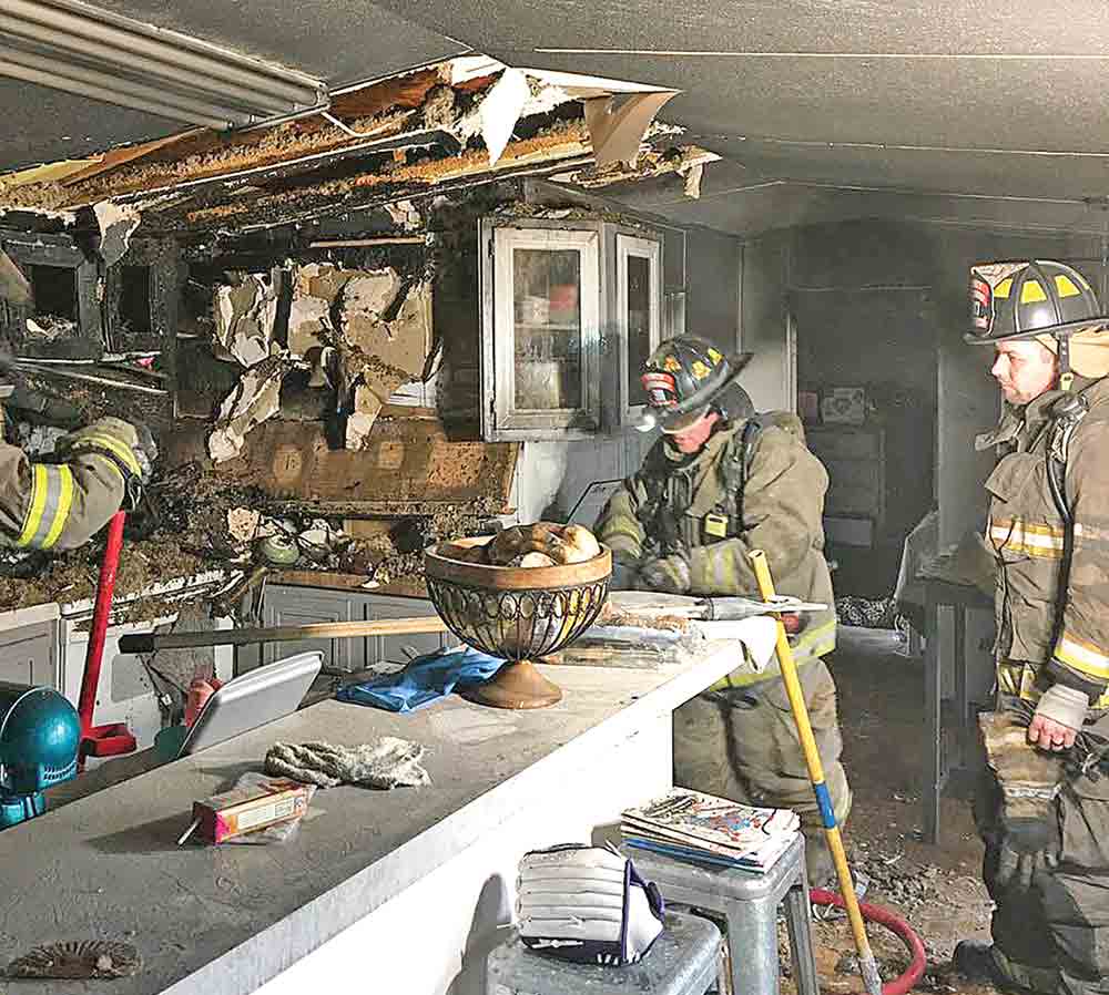 Firefighters from Trinity Fire & Rescue examine the scene of a fire.