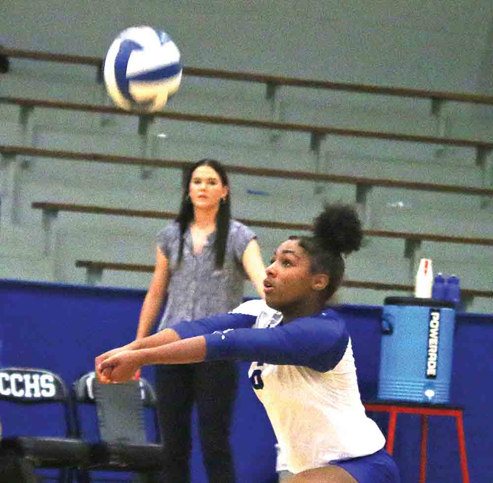 Keiona Moore gets the dig, as Coach Grace Beckmeyer looks on.