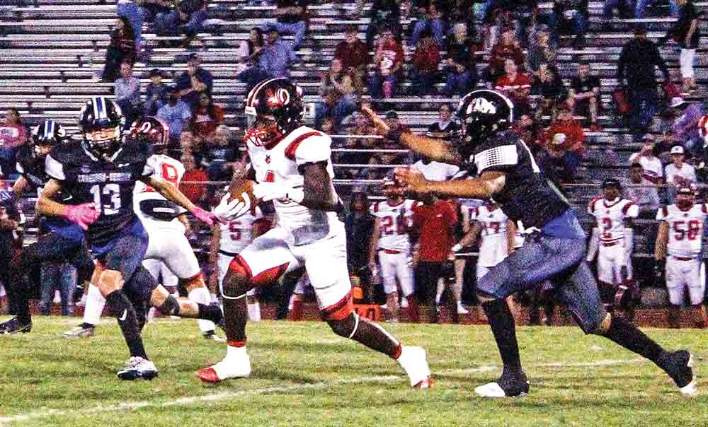 Trojan junior back Tyga Parker starts to break away on a run in the first half. Photo by Albert Trevino