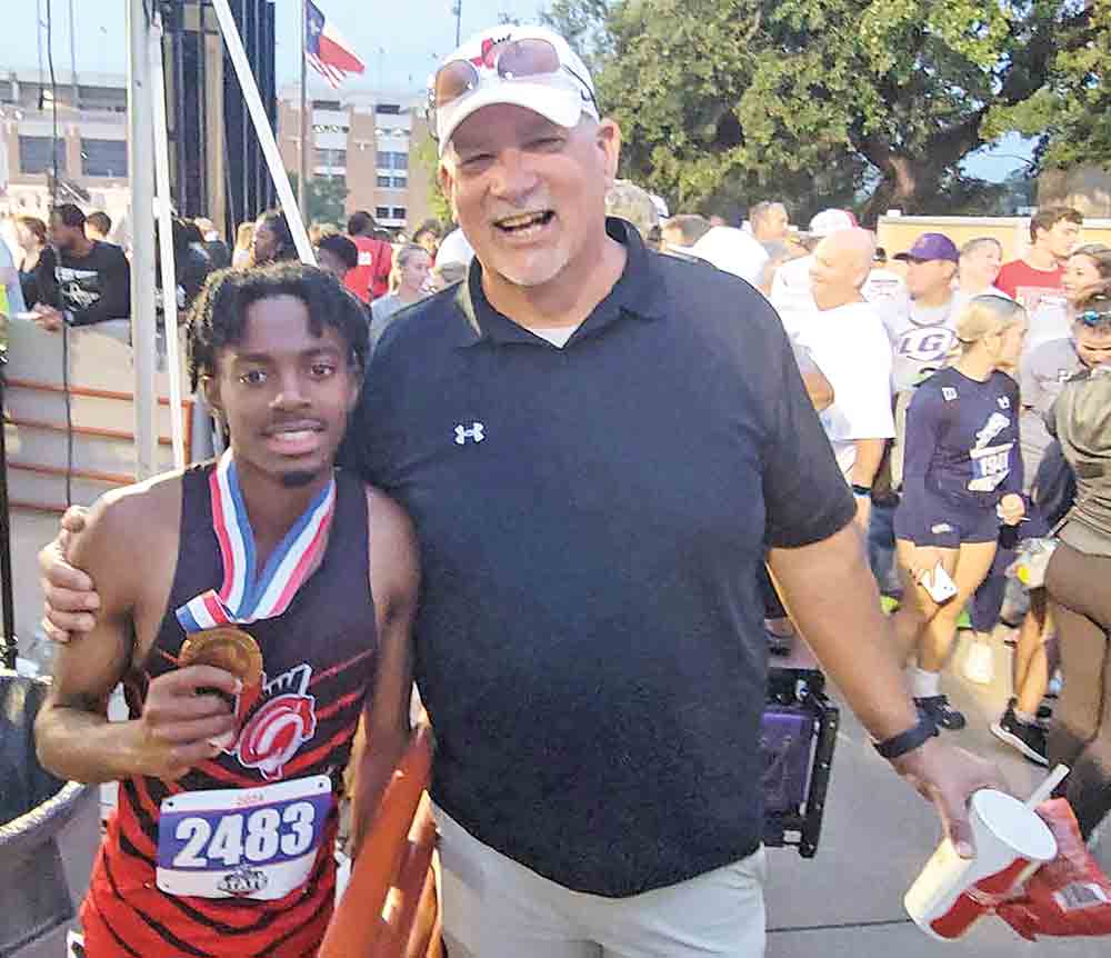 In the record book  Coldspring-Oakhurst CISD Athletic Director Ken Stanly congratulates Christian Lee, who finished third in the 200-meter dash with a time of 21.68 at the recent State Track Meet. Courtesy photo